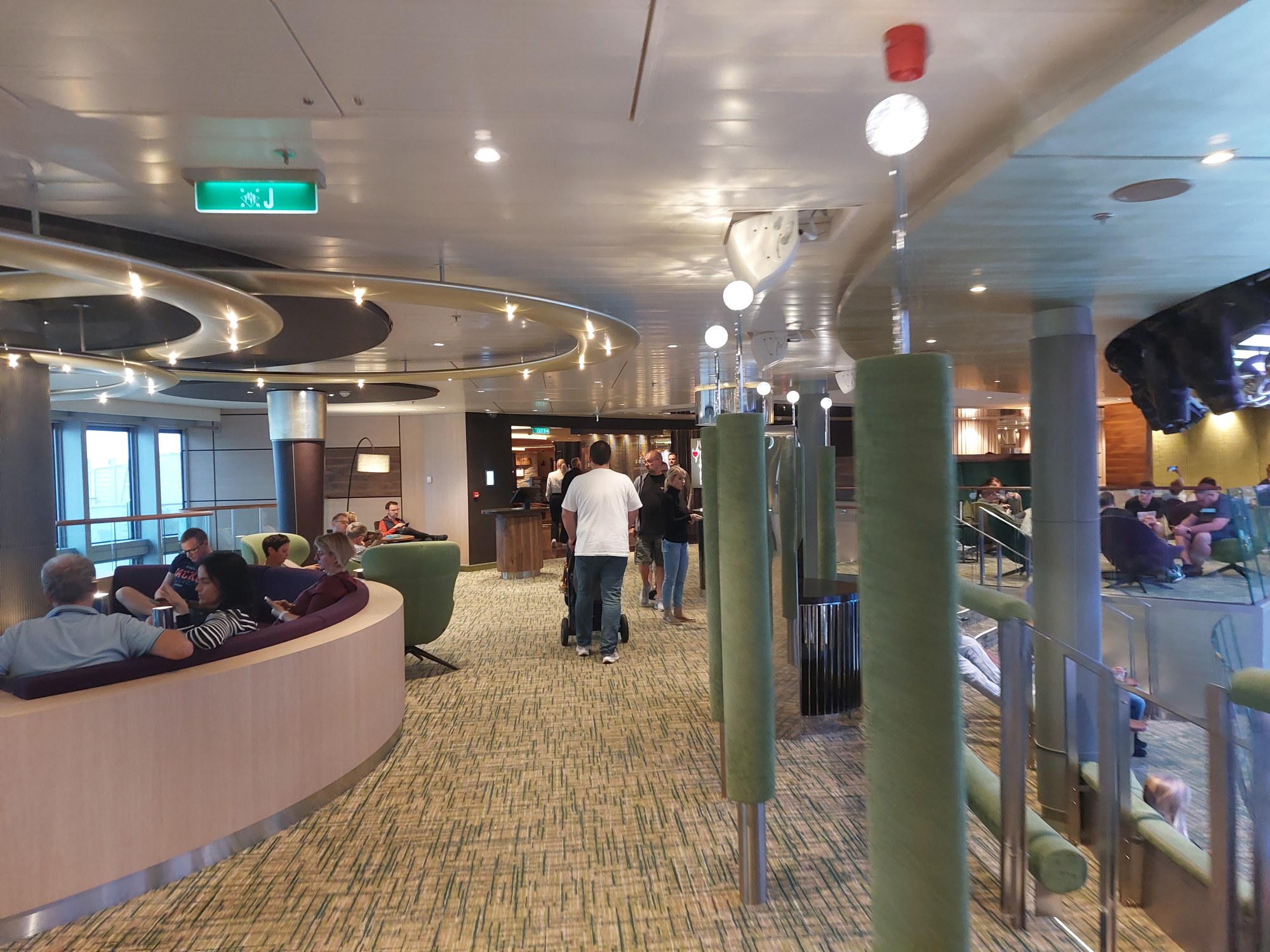 Papa schiebt den Buggy durch eine Lounge an Bord der AIDA Cosma