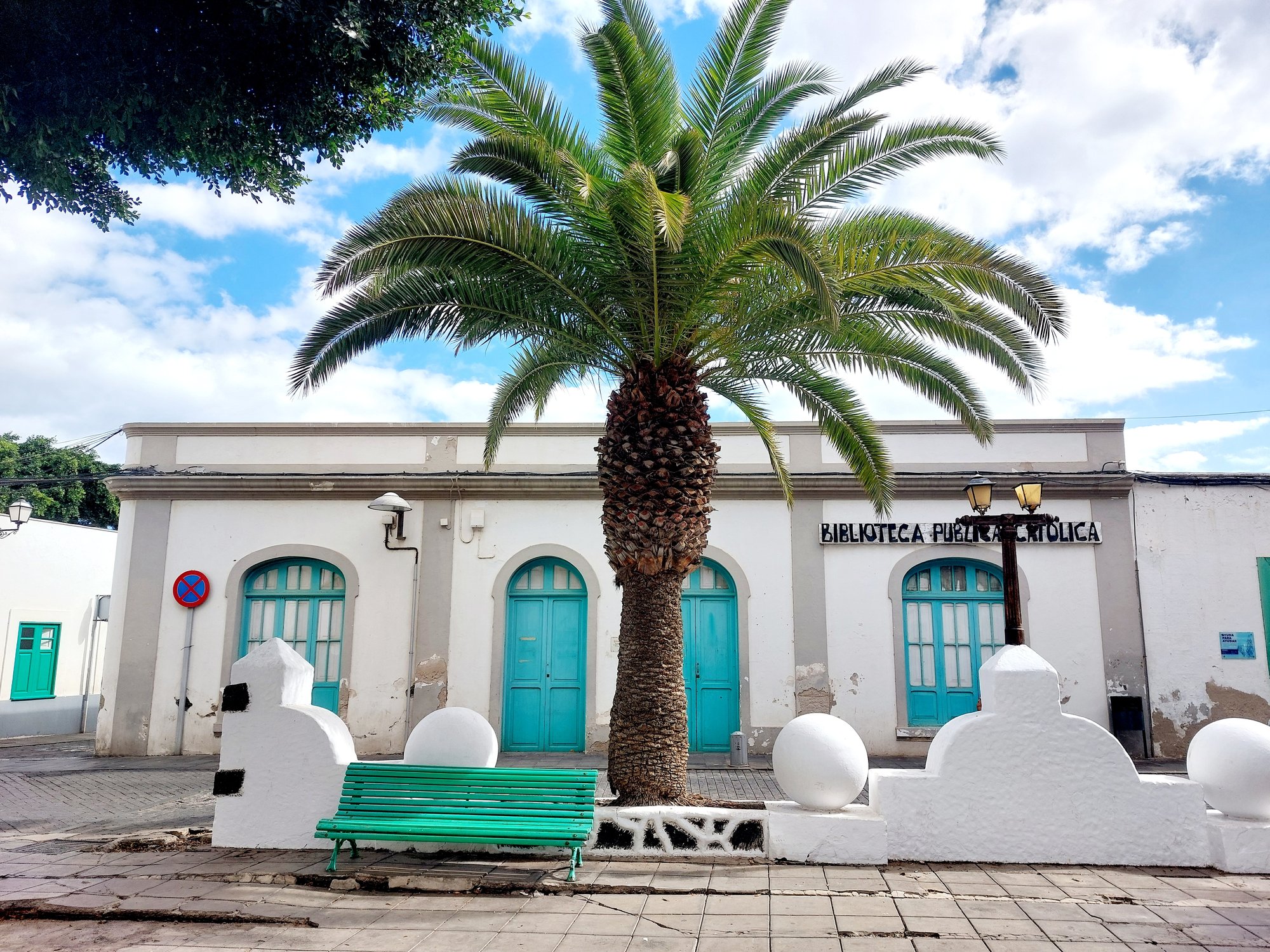 Biblioteca Pública Católica in Arrecife mit türkisen Türen und Palme