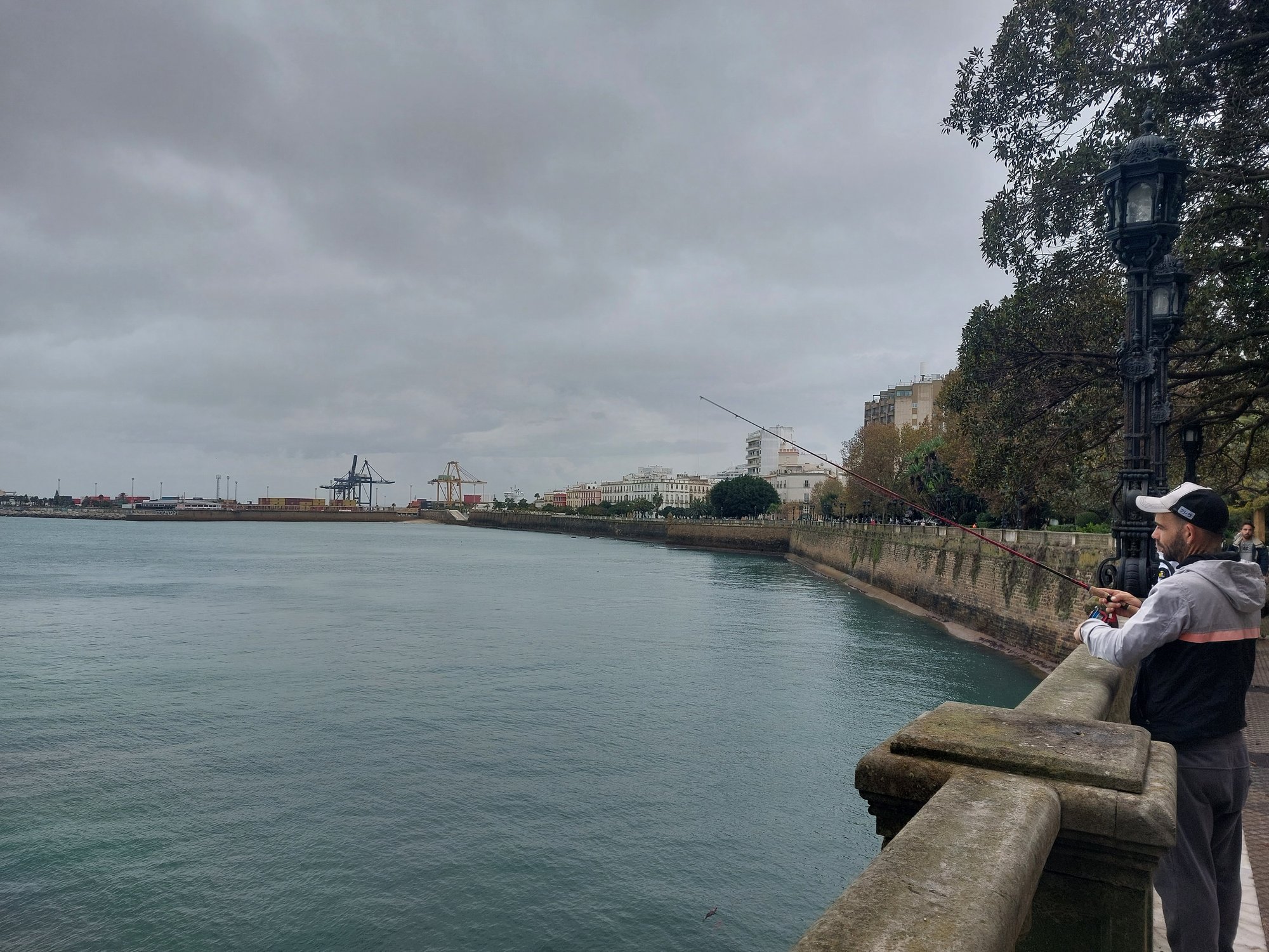 Angler an der Hafenmauer von Cádiz mit Blick auf den Hafen