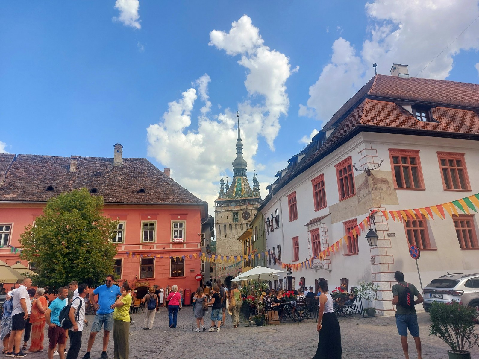 Bunter Hauptplatz von Sighișoara mit dem Stundturm im Hintergrund